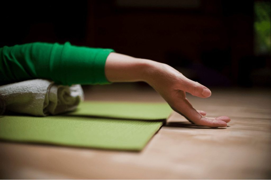 Hand laying on yoga mat