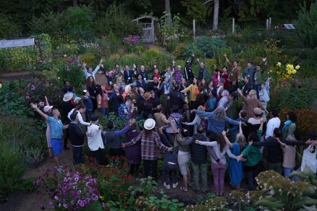 Hollyhock´s staff and students together in the garden celebrating and raising hands.